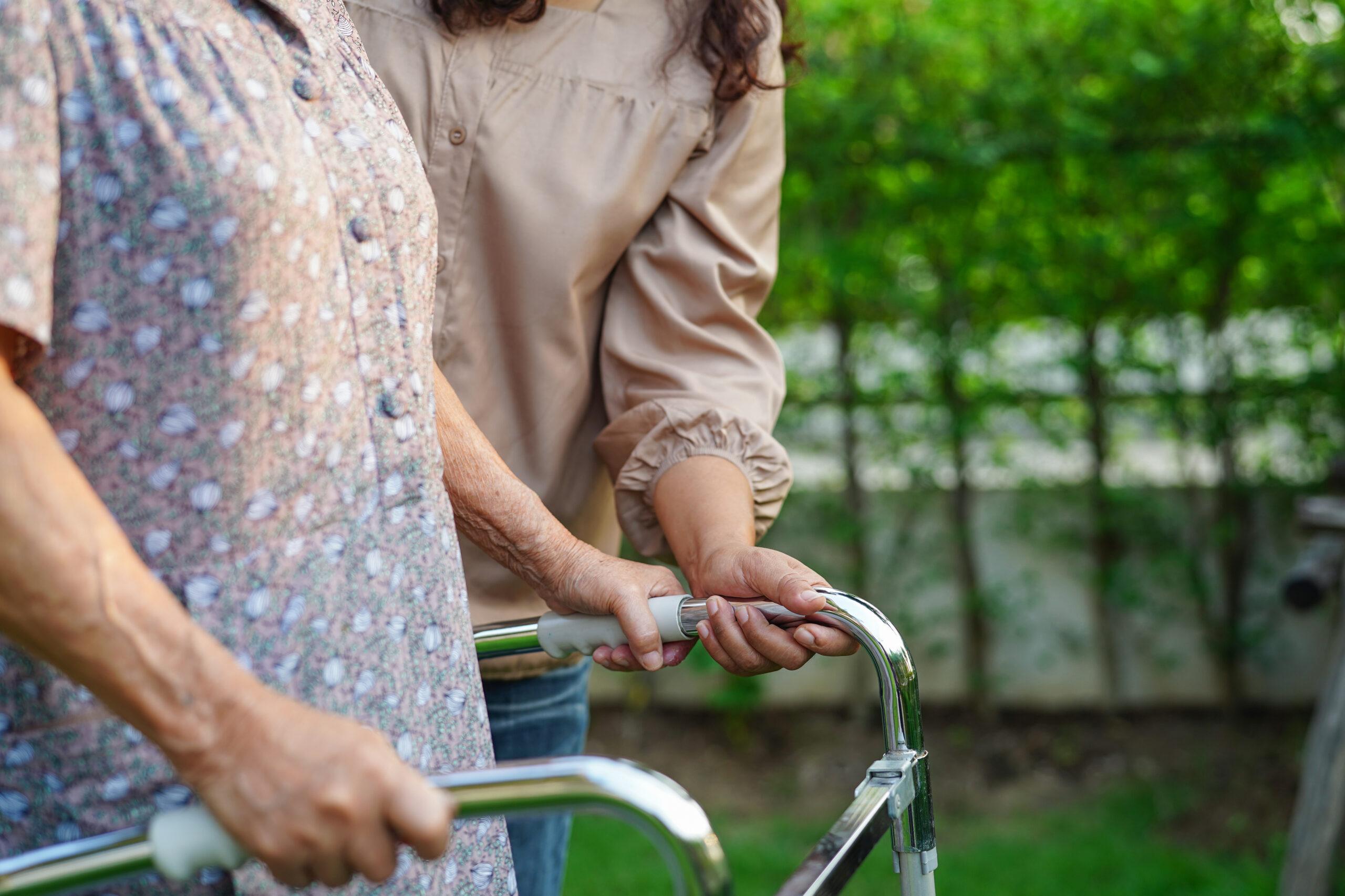 Caregiver help Asian elderly woman disability patient in nursing